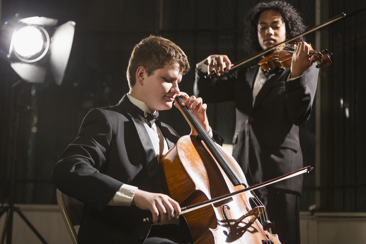 Teenage boys playing double bass and violin in concert How Ensemble Playing Builds Confidence In Kids